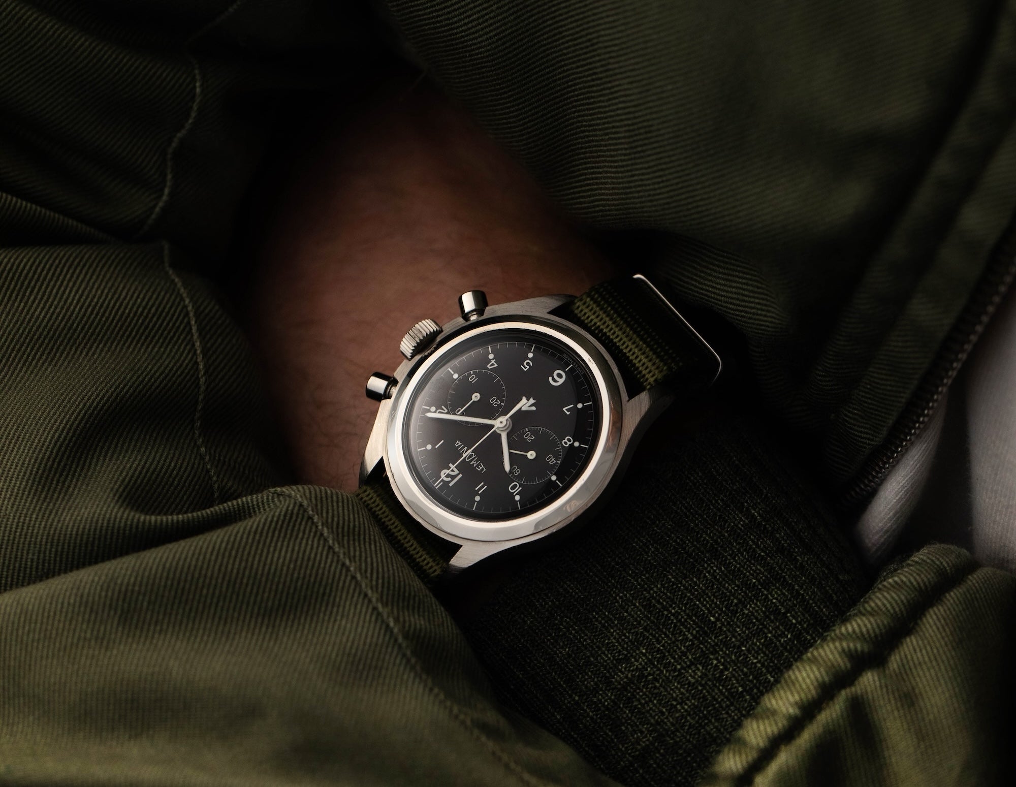 Lemania chronograph in yellow gold with black dial petting a dog